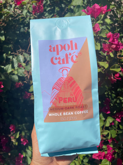 Coffee bag labeled 'apoh cafe Peru' held against a floral background